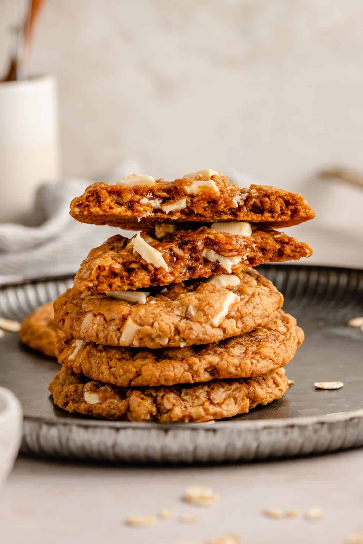 Biscoff cookies in a stack on a plate with one broken in half showing gooey insides